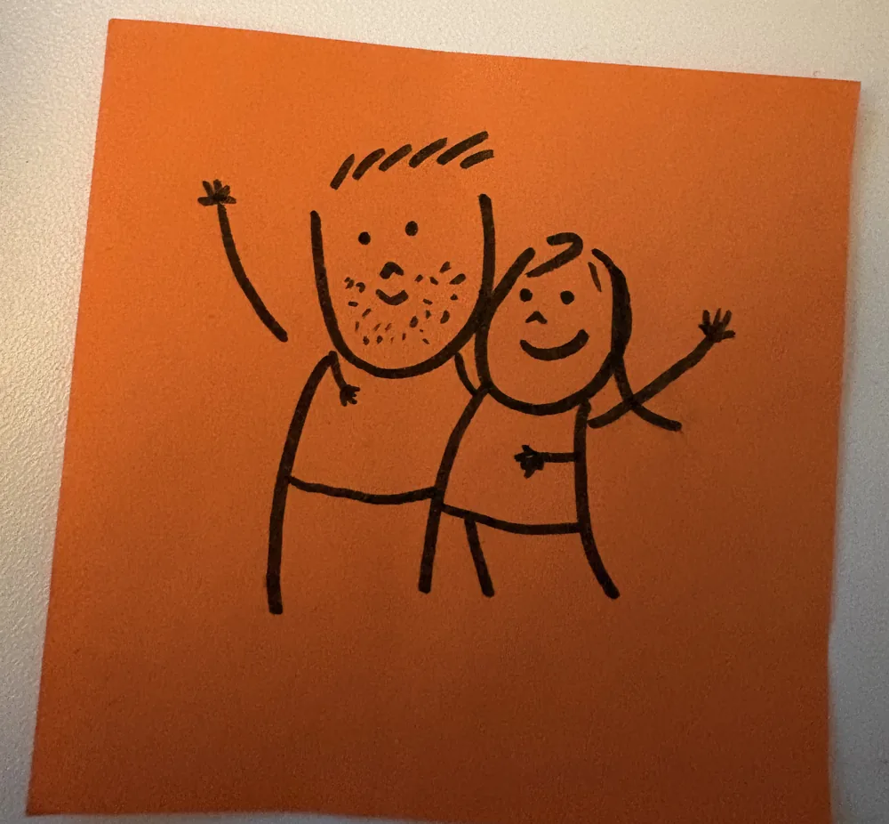 A hand-drawn sketch on an orange sticky note of two smiling figures waving, arms around each other